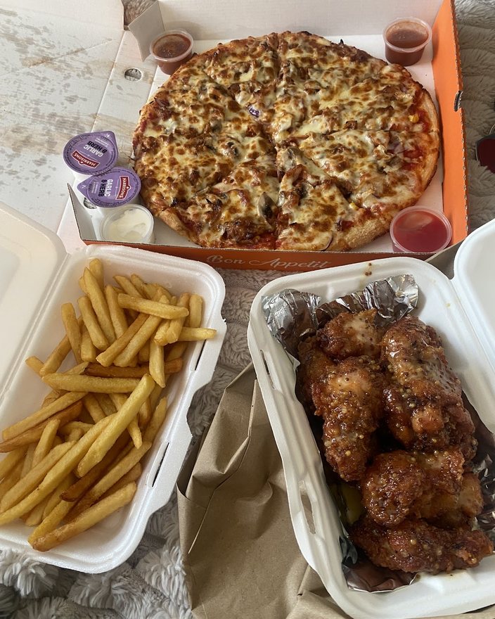 Pizza, fries and wings laid out to share